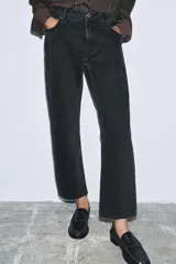 Jeans de tiro medio con corte slim leg, confeccionados en denim color beige. Presentan cintura con trabillas, diseño clásico de cinco bolsillos y cierre frontal con cremallera y botón metálico.