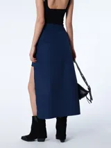 Falda midi azul marino de corte asimétrico con abertura lateral y cierre invisible.