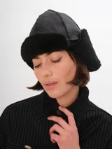 Gorro tipo aviador de cuero marrón con interior de piel sintética color beige.