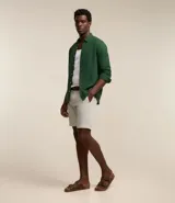 Bermuda de hombre de corte recto, confeccionada en una mezcla de lino y algodón. Presenta cintura con trabillas, cierre frontal con botón y cremallera, y dos bolsillos laterales.