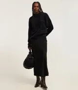 Suéter de punto color crema con cuello redondo y mangas largas ajustadas. Modelo slim alargado con efecto de pelitos.