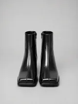 Bota de cuero color negro, de caña corta con punta cuadrada y taco bloque bajo.