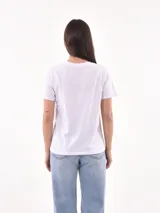 Remera blanca de manga corta y cuello redondo, con estampa frontal ilustrada de una mujer con boina y vestido con patrón animal print.