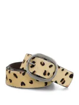 Cinturón de cuero natural con textura de pelo y estampado animal print. Presenta una hebilla metálica ovalada en tono plata envejecida y siete agujeros para ajuste.