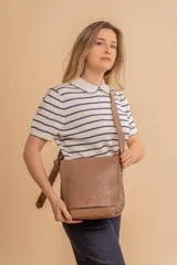 Bandolera de diseño simple con tapa frontal, confeccionada en material símil cuero. Cuenta con correa ajustable, división interna y bolsillos internos para mayor organización.