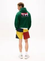 Buzo verde con capucha y cordón distintivo, bolsillo canguro, puños y bajo de punto canalé, logo oversize de Tommy Hilfiger en la manga y la parte trasera, parche con logo de Tommy Hilfiger en el pecho y detalles distintivos de Hilfiger Sailing.