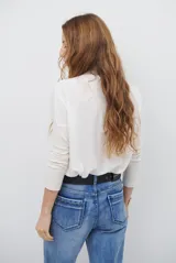 Remera de manga larga color bordó con cuello redondo en contraste color crema y costuras decorativas visibles en el ruedo y puños.