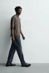 Pantalón jeans straight ankle fit de tiro medio, confeccionado en denim de algodón con efecto lavado. Presenta diseño de cinco bolsillos y cierre frontal con cremallera y botón.