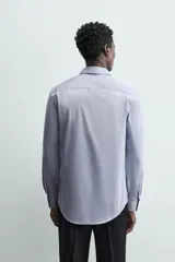 Camisa de algodón de manga larga, color celeste claro, con cuello italiano y cierre frontal de botonadura.