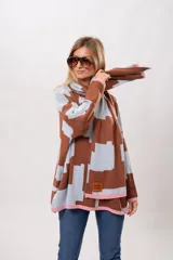 Buzo oversize de algodón con estampado geométrico en tonos marrones y celestes, con cuello y puños en color rosa.