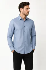 Camisa blanca de algodón, de diseño holgado y manga larga, con cuello camisero y cierre frontal de botones.