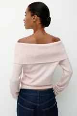 Buzo corto de punto suave color rosado, con escote off-the-shoulder con doblez ancho acanalado. Tiene ajuste entallado y remates acanalados en puños y bajo.