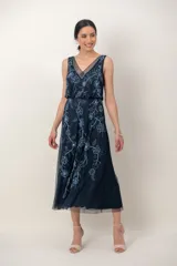 Vestido midi azul marino de tul, sin mangas, con escote en V y delicado bordado de flores con canutillos y lentejuelas en tonos celestes.