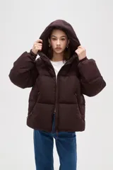 Campera puffer de color marrón oscuro, con diseño capitoneado, cierre frontal, capucha ajustable y bolsillos laterales con cierre.