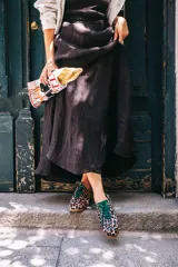 Zapatillas de estilo running con estampado animal print de leopardo sobre fondo rosado. Presentan detalles en color verde botella en la lengüeta, cordones, collarín y talón. Cuentan con suela de goma dentada y cuña interna oculta para mayor comodidad.