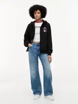 Cortavientos negro con capucha fija, cierre frontal de cremallera con cinta distintiva y puños elásticos. Presenta logos de la colaboración Cadillac Formula 1 Team en el pecho y diseño de corte regular.