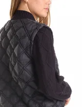 Campera combinada Current Air, con torso acolchado en diseño de rombos y mangas de tejido de punto grueso con diseño de ochos. Presenta cierre frontal metálico, cuello alto y puños y ruedo acanalados.