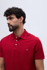 Remera polo verde militar de algodón pima, con cuello y puños acanalados, cierre frontal de tres botones y pequeño bordado de ave en el pecho.