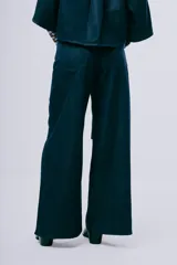 Pantalón wideleg de denim azul oscuro, de tiro alto y corte amplio con bolsillos laterales y cinturón incorporado.