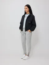 Pantalón deportivo tipo jogging color gris melange, confeccionado en 60% algodón y 40% poliéster, con cintura elástica ajustable con cordón y puños ajustados con cierre.