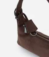 Cartera tipo shoulder bag de tamaño pequeño, confeccionada en material sintético con acabado tipo gamuza y textura crocco. Presenta una correa de hombro fija con hebillas metálicas decorativas en los laterales y cierre superior por cremallera.