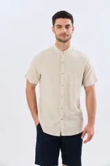 Camisa de lino y algodón de manga corta, color negro, con cuello mao, cierre frontal con botones y bolsillo ojal en el pecho.