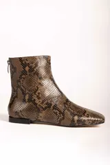 Botas cortas de gamuza color marrón, con punta cuadrada y cierre lateral. Diseño minimalista con costura central vertical.