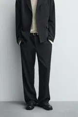 Pantalón de corte relaxed fit confeccionado en tejido con mezcla de lana, con bolsillos delanteros y traseros de vivo, cierre frontal con cremallera y botón.