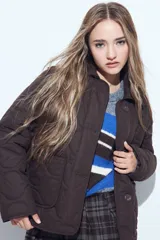 Campera capitoneada de diseño acolchado con patrón de ondas, cierre frontal con botones y bolsillos laterales amplios.