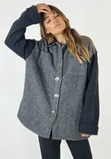 Chaqueta gris con frente de espiga y mangas largas de punto acanalado.