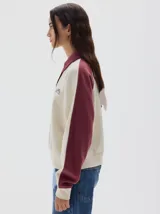 Buzo de friza suave color azul marino, con cuello polo y cartera de botones en contraste azul denim. Mangas raglán con franjas laterales azules y logo bordado en el pecho.