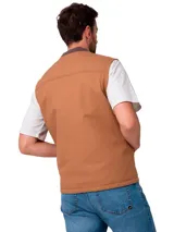 Chaleco de trabajo Caterpillar en color tostado, confeccionado en lona resistente. Presenta cierre frontal completo, cuello tipo bomber en tejido acanalado, bolsillos frontales tipo parche y etiqueta de la marca en el pecho.