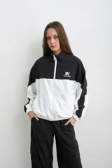 Campera estilo aviador de tela avión, en diseño bicolor negro y blanco, con cierre frontal y cuello alto. Cuenta con bolsillos laterales con cierre y bordado de la marca Mandinga en el pecho.