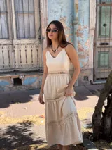 Vestido largo color beige, con tirantes finos, escote en V y detalles de inserciones de encaje broderie en la cintura y los volados de la falda.