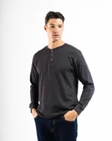 Remera tipo henley de manga larga confeccionada en tejido de algodón con textura mini piqué. Presenta un cierre frontal con tres botones y puños ajustados en las mangas.