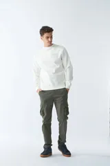 Buzo de felpa color crudo, de corte recto, con cuello redondo, puños y ruedo acanalados.