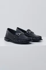 Mocasín negro de cuero con textura tipo cocodrilo, detalle de estribo metálico plateado en el empeine y costuras reforzadas en la puntera.