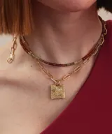 Collar de plata con cadena de eslabones alargados y dije de medalla rectangular con textura rústica, grabado en relieve con forma de estrella y una piedra brillante incrustada en el centro.