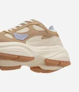 Championes de estilo urbano y deportivo de la marca Satinato, modelo jogging, confeccionados en poliuretano y poliéster en tonos beige, tostado y lila. Presentan una suela robusta texturizada y detalles en malla respirable.