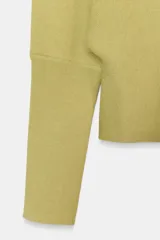 Jersey de punto color verde lima, con cuello pico y manga larga de sisa ancha que se estrecha hacia la muñeca.