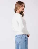 Buzo blanco de tejido calado con perlas bordadas, cuello a la base y manga larga, de la marca Nanette.