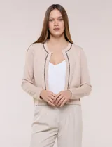 Cardigan corto azul marino de punto, con silueta entallada y largo a la cintura. Cuenta con un ribete decorativo que recorre el cuello redondo y la abertura frontal, integrando una cadena dorada en contraste. Posee bolsillos delanteros simulados y mangas largas.