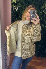 Campera acolchada de corte recto con estampado animal print en tonos neutros. Presenta cierre frontal con botones, cuello redondo y ribetes en color contrastante.