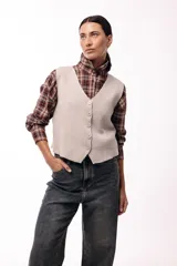 Chaleco tejido de punto con escote en V y cierre frontal con botones. Presenta una silueta recta y un diseño minimalista.