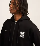 Saco negro con cierre de cremallera, capucha con cordón de ajuste, mangas largas y bolsillos. Estampa frontal con la frase "See you out there" en letras blancas.