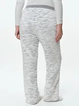 Pantalón de dormir de corte recto confeccionado en tela fleece con estampado animal print. Presenta una cintura elástica de algodón en color gris y una textura suave y abrigada.