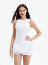 Vestido negro sin mangas, ajustado en la parte superior y con falda corta tipo globo o bombacha fruncida con cordón ajustable en la cintura.