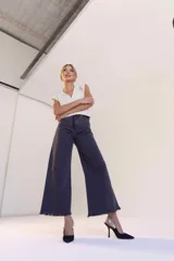 Pantalón denim azul oscuro de corte ancho con terminación desflecada.