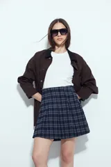 Minifalda de tablas con diseño a cuadros en tonos azul oscuro y gris, de estilo preppy y corte colegial.