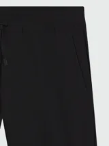 Pantalón de corte recto y estilo casual, confeccionado en tejido técnico elástico. Presenta cintura elástica con cordón de ajuste y bolsillos laterales.